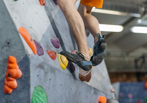 Close-up on feet wearing athletic shoes on a yoga mat.