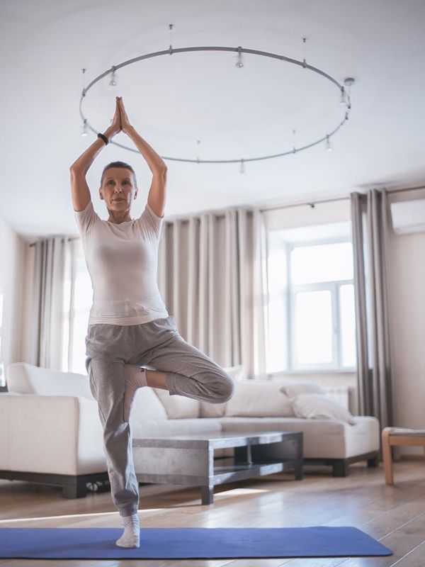 Full body shot of a person mid-stride during a home workout.